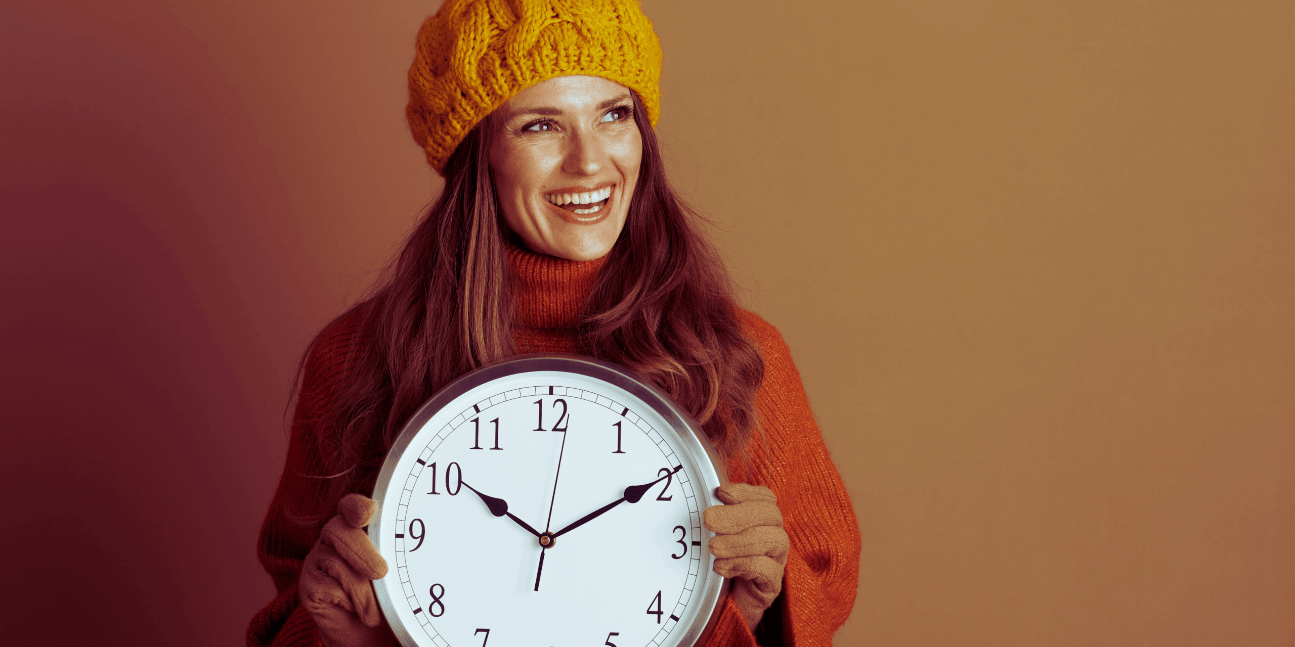 usměvavá žena s hodinami jako reakce na změnu času z letního na zimní