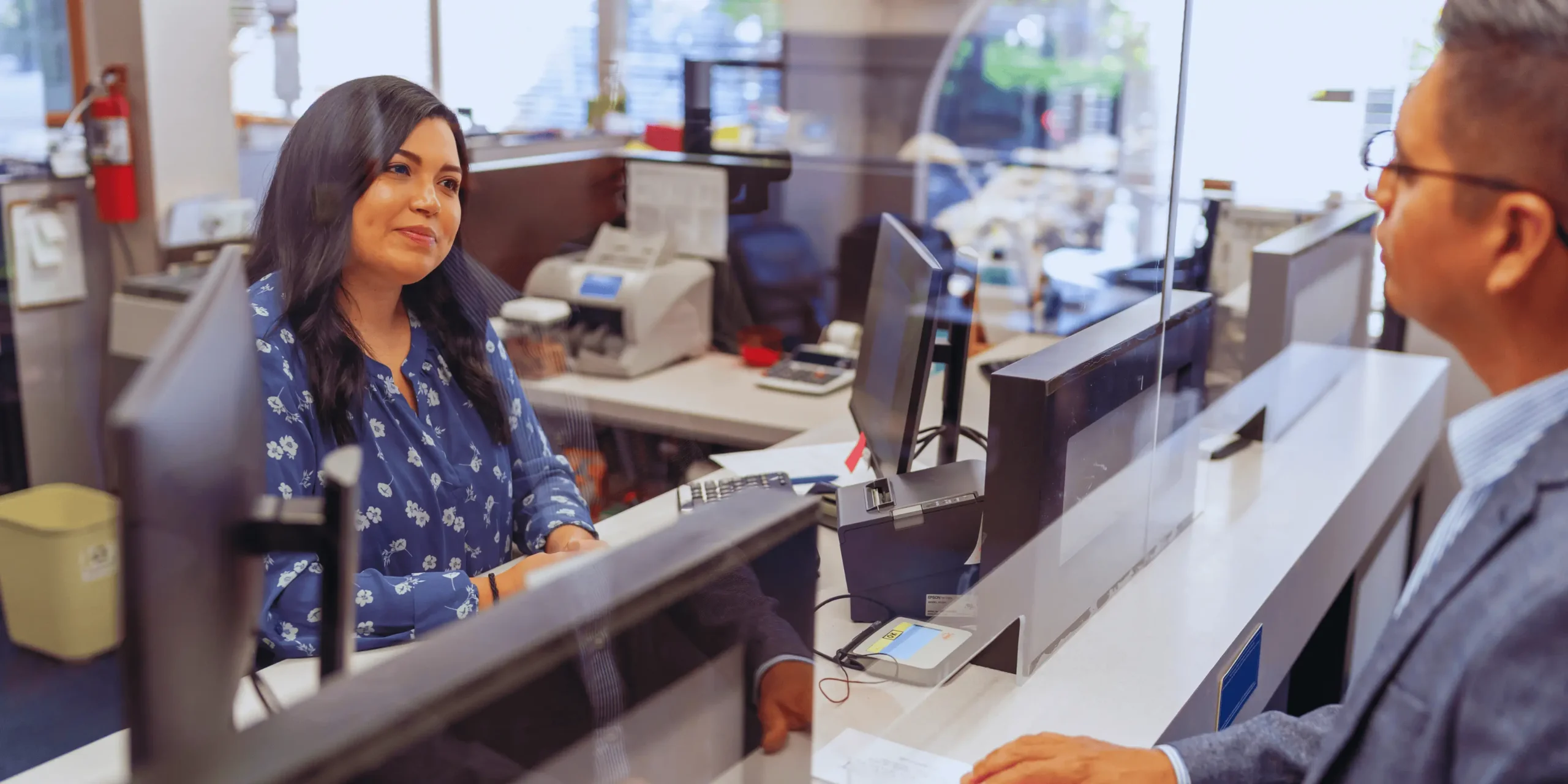 Paní na přepážce v bance u pokladního.